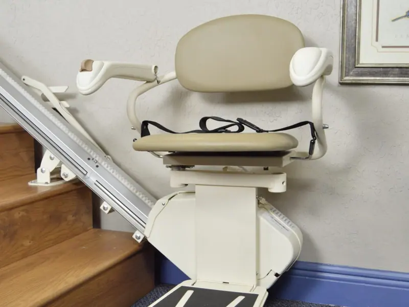 Cream straight stairlift folded neatly at the foot of an indoor staircase