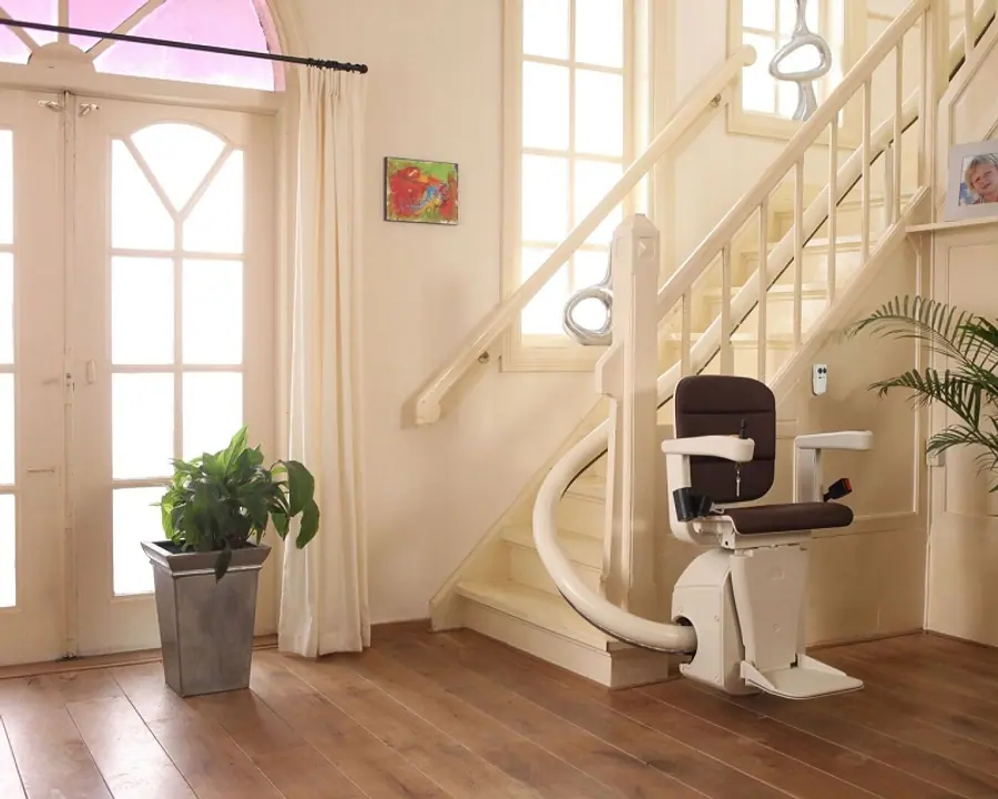 Curved stairlift rail sweeping around a landing on an elegant home staircase